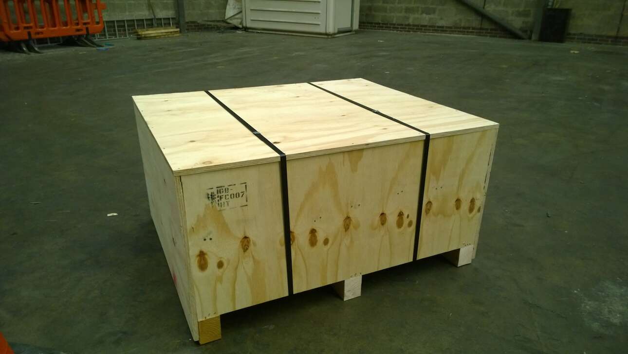 A secured wooden shipping box in a warehouse ready for delivery